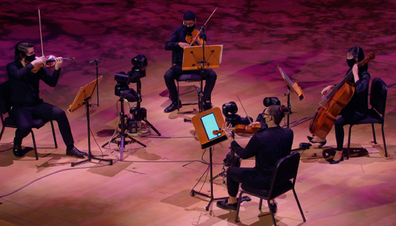 Des musiciens jouant avec des caméras éloignées sur scène pour la diffusion en direct.