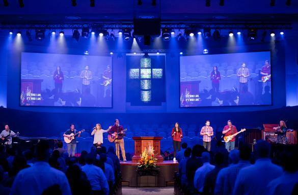 Intérieur de l'église avec un groupe se produisant sur scène et le public au premier plan.