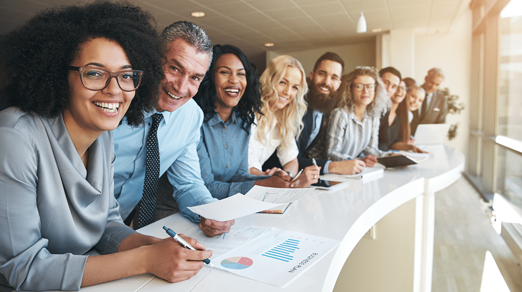 Diverse group of professionals leaning against a boardroom table