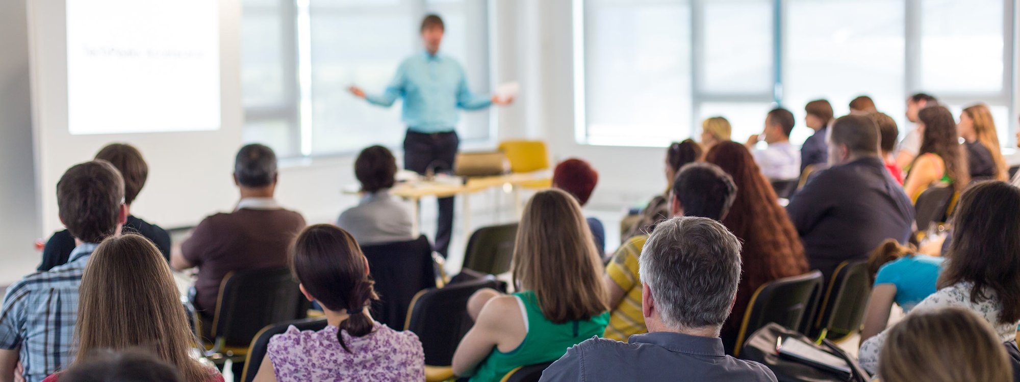 A seated audience watches a presentation
