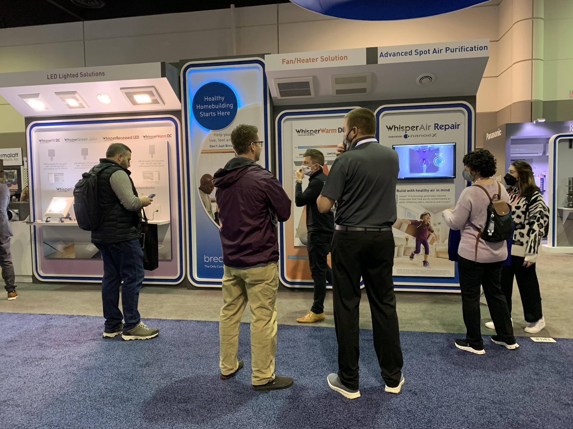 Trade show attendees gather around a Panasonic display