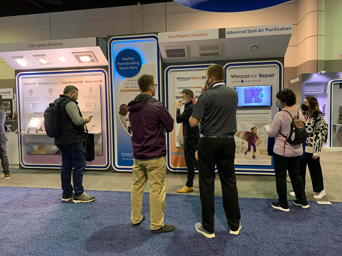 A group of people gather around a trade show display