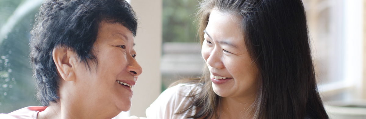 A younger woman and an older woman smile together
