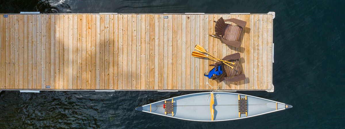 A canoe sits in the water alongside a dock