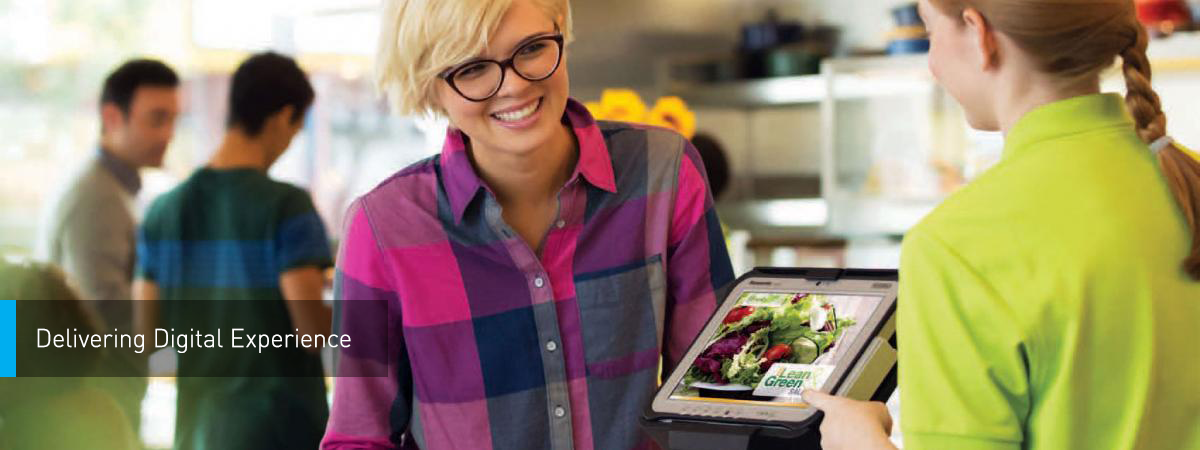 An employee at a fast food restaurant takes a customer's order over a digital screen
