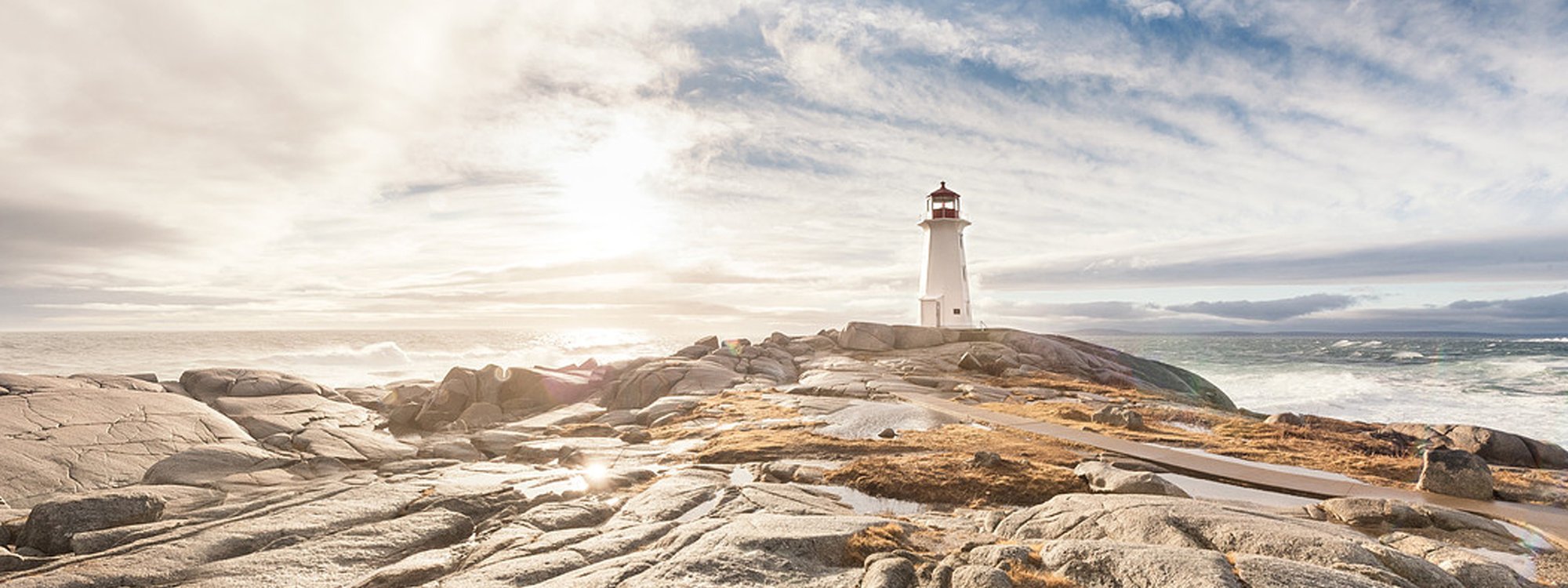 A lighthouse stands on a rocky coastline 