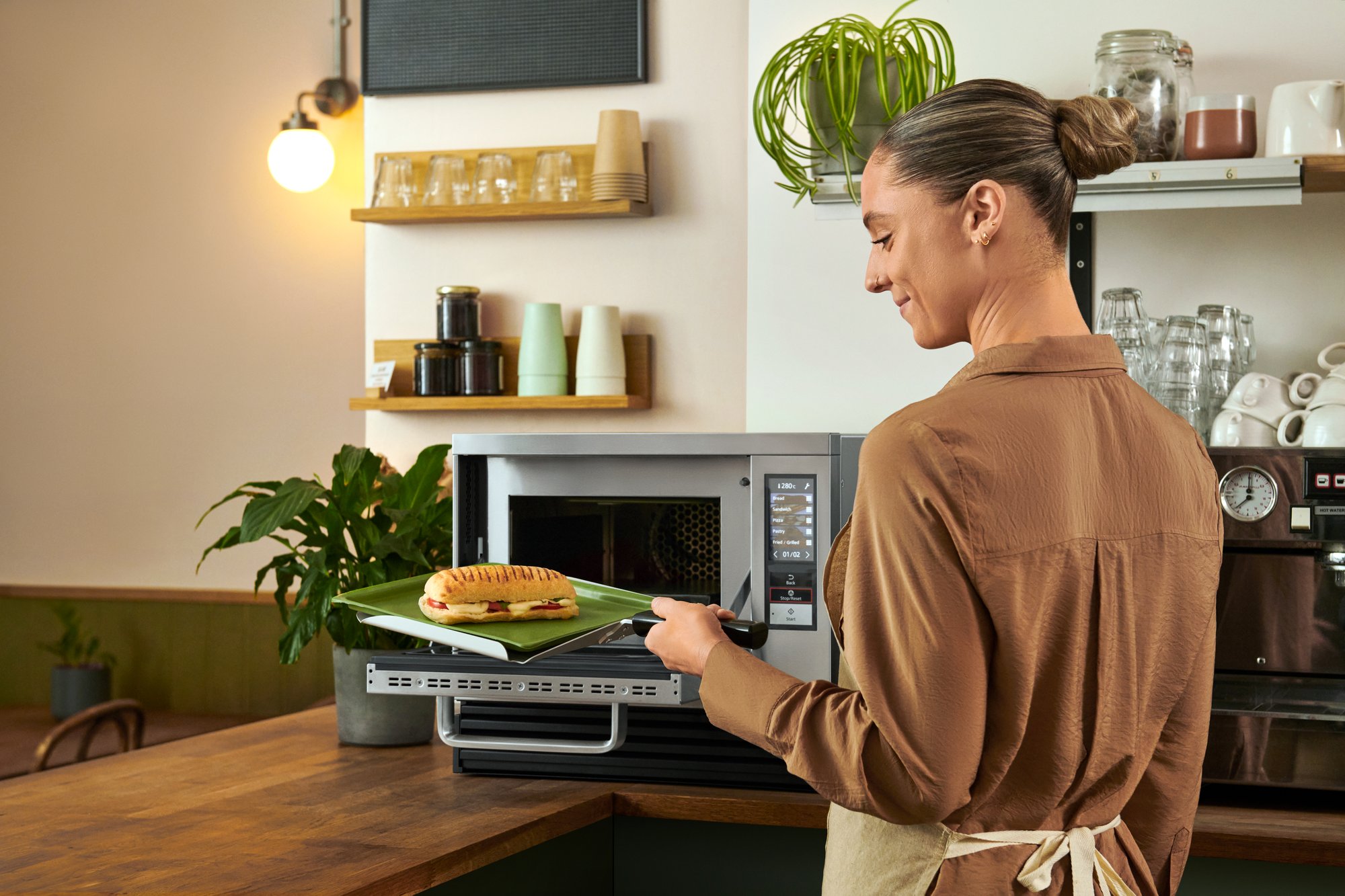 A chef is putting in bakery product into Panasonic NE-SCV3N high speed oven for reheat.