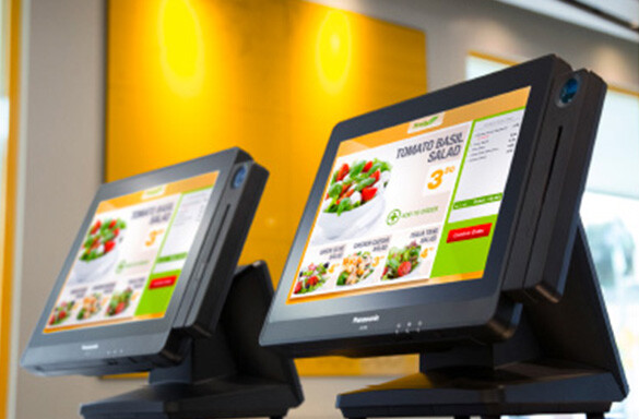 Two point-of-sale systems sitting on a counter with menu displayed