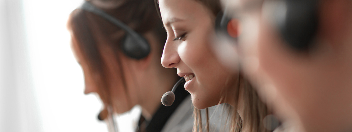 Closeup of woman working at help desk with headset on