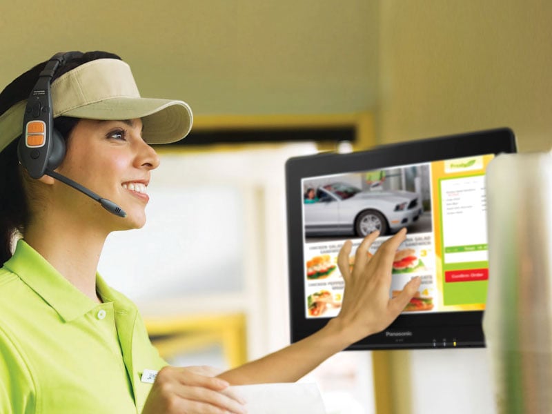 A fast food employee enters an order on a touch screen