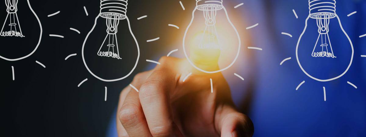 A finger touches a lightbulb, lighting it up