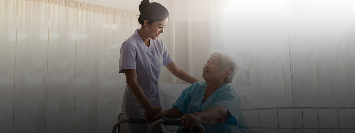 A nurse assists a senior in a brightly lit room