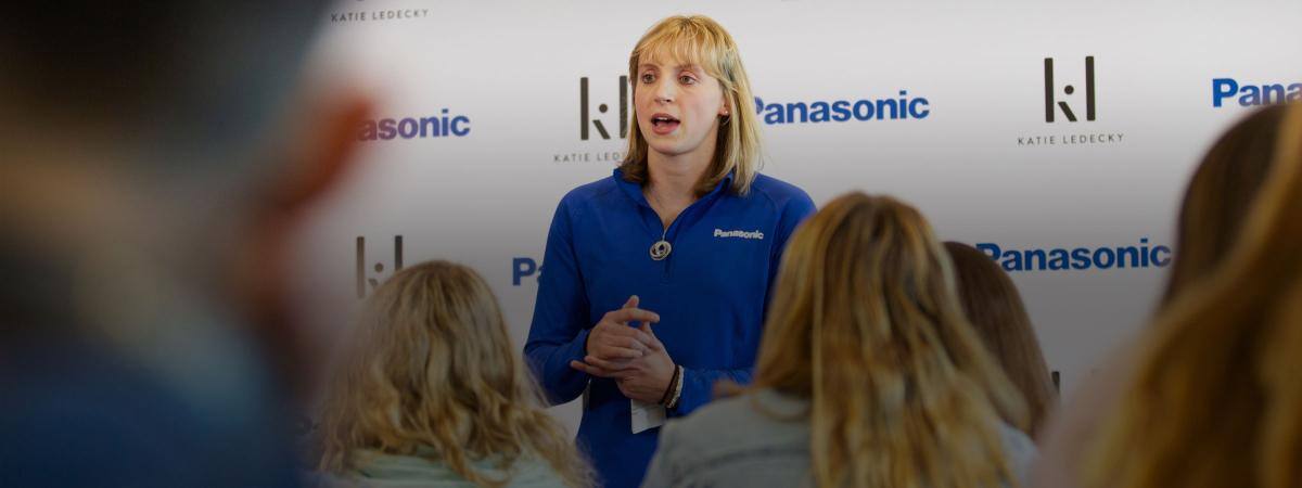 A woman speaks in front of a group of people
