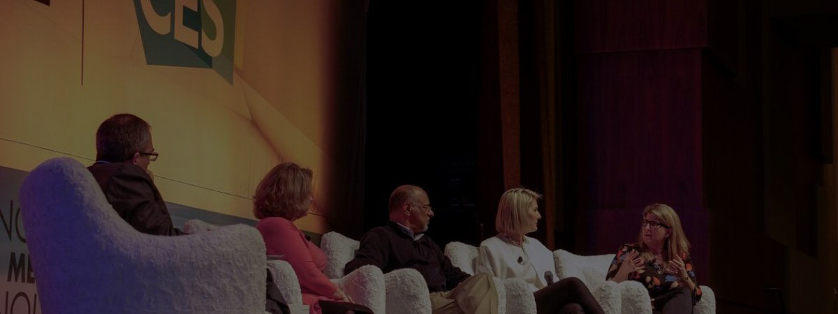 Participants in a discussion panel sit and talk on a stage