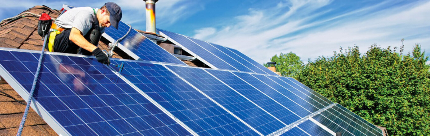 Man installs solar panels on a roof
