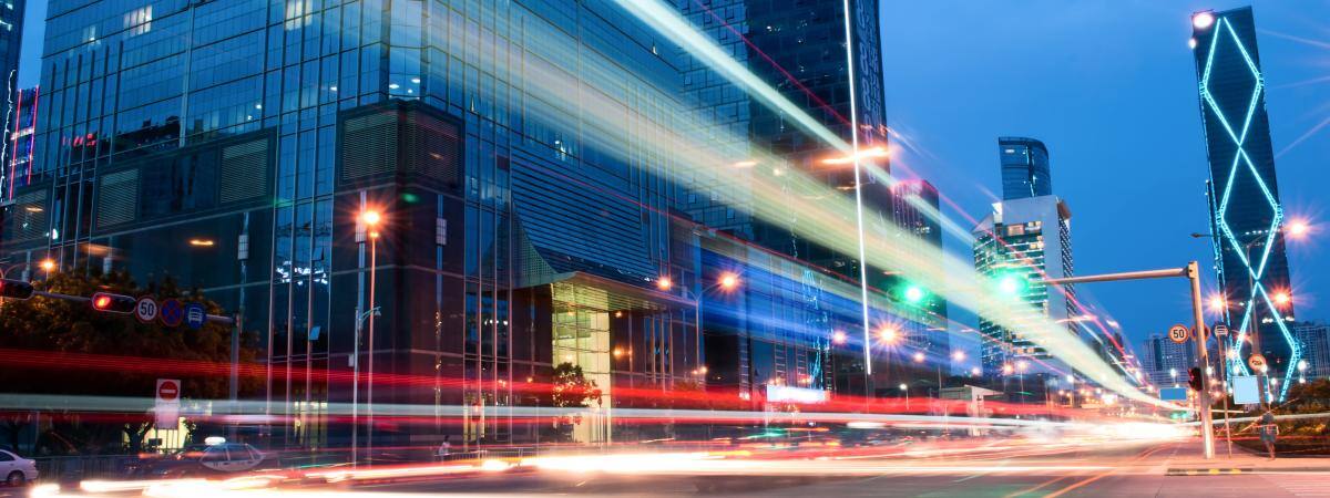 Streaks of brightly coloured light travel down a city street