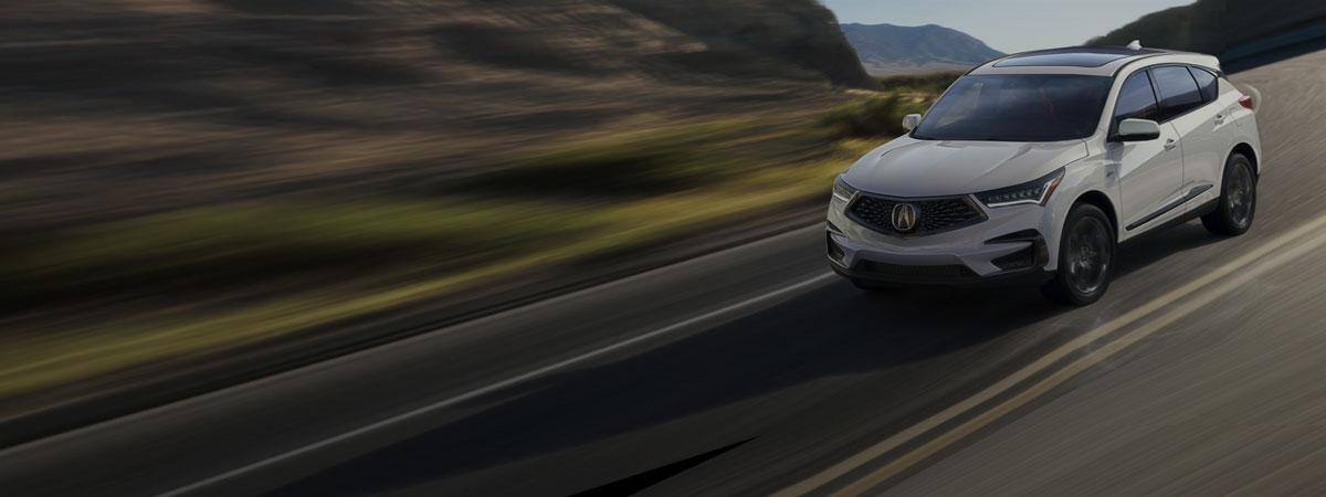 An SUV drives down a mountain road