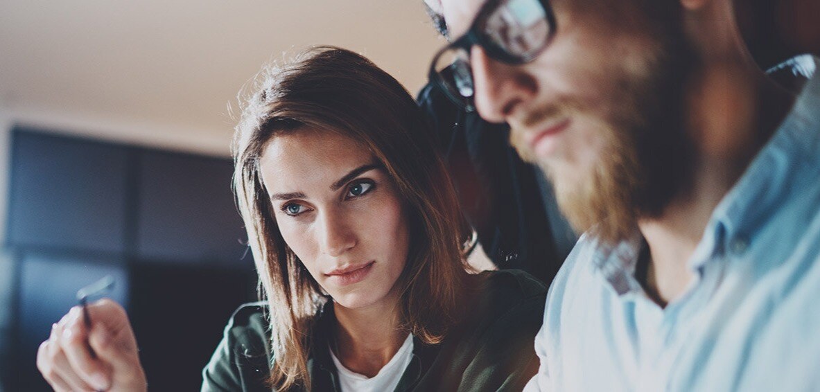 Woman and man staring intensely at computer screen