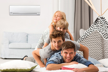 Father laying on pillows with elder son, younger son and youngest daughter laying on his back, with Panasonic HVAC unit mounted to wall behind them