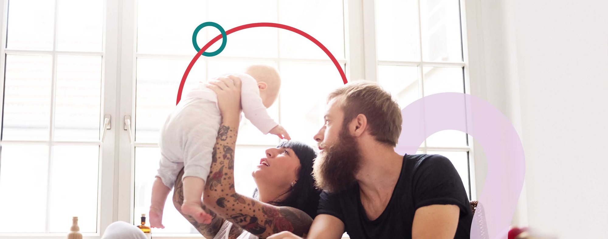 Famille jouant avec bébé dans une salle lumineuse avec de grandes fenêtres.