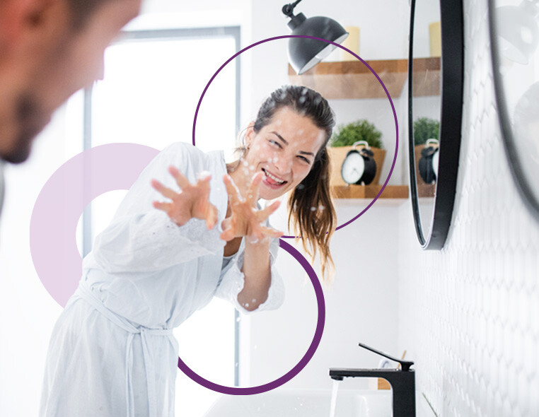 Robinet de salle de bain moderne dans une pièce brillamment éclairée avec une interaction ludique en arrière-plan.