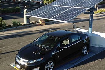 Electric car charging underneath a solar panel in a parking lot