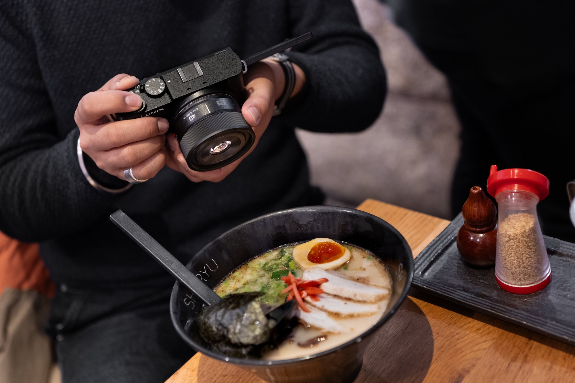 A person taking picture of soup/food with a camera with SS40 lens attached