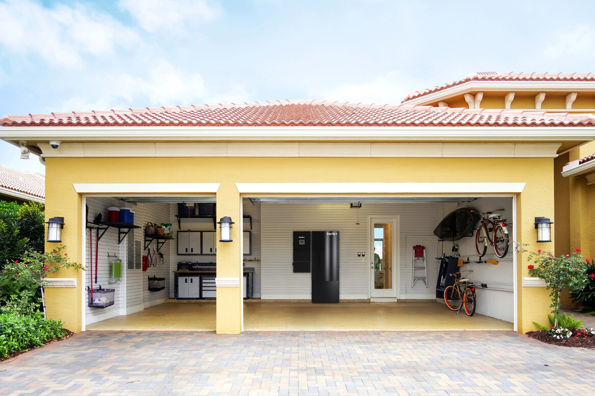 Front of garage with doors open and solar storage battery and car charging station mounted to wall