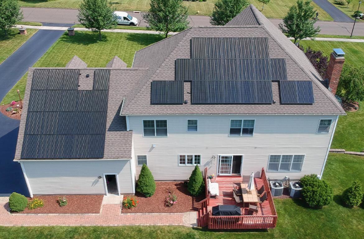 Arial view of two story house with roof covered in solar panels