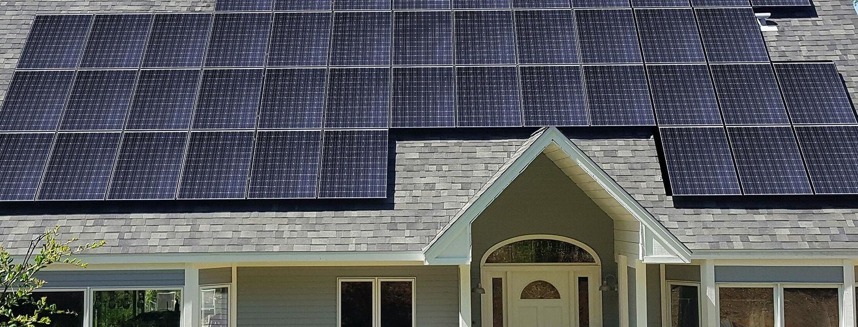 Closeup of house roof covered in black solar panels