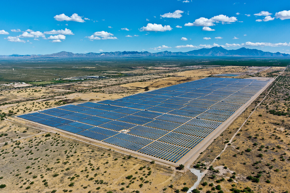 Arial shot of a large solar array located in the desert surrounded by mountains