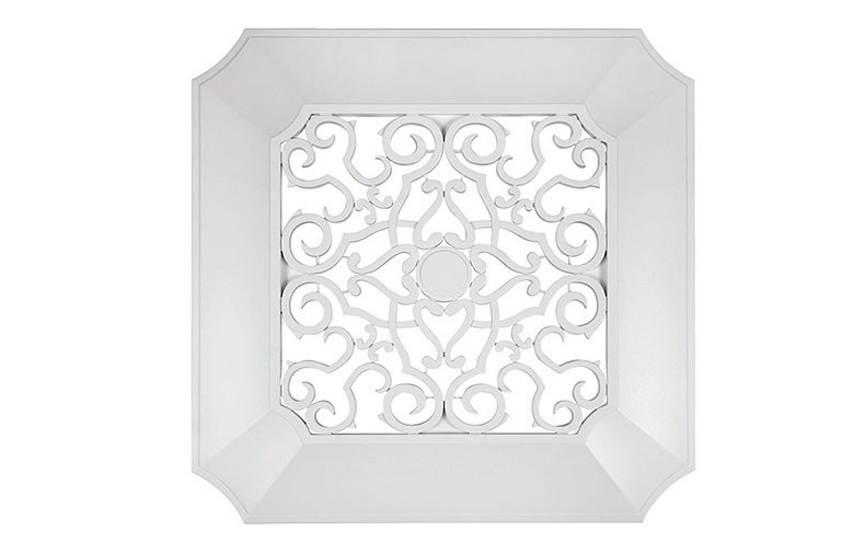White decorative ventilation fan cover with ornate scroll design.