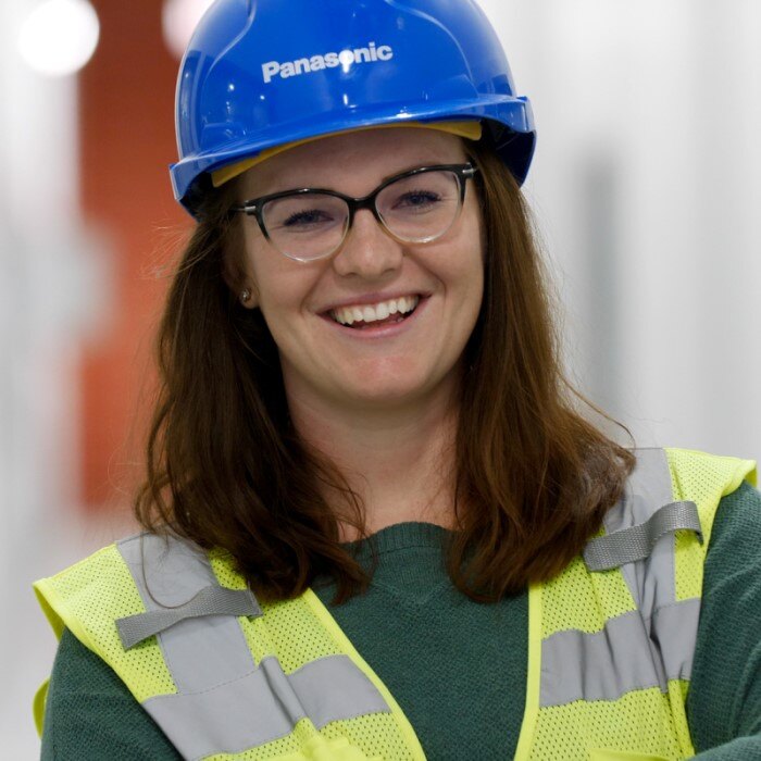 Abby Chitwood smiles in a hard hat and reflective vest