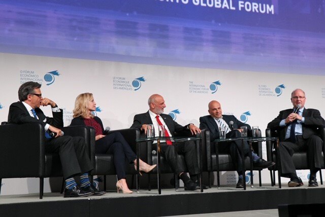 A panel of speakers sit on a stage