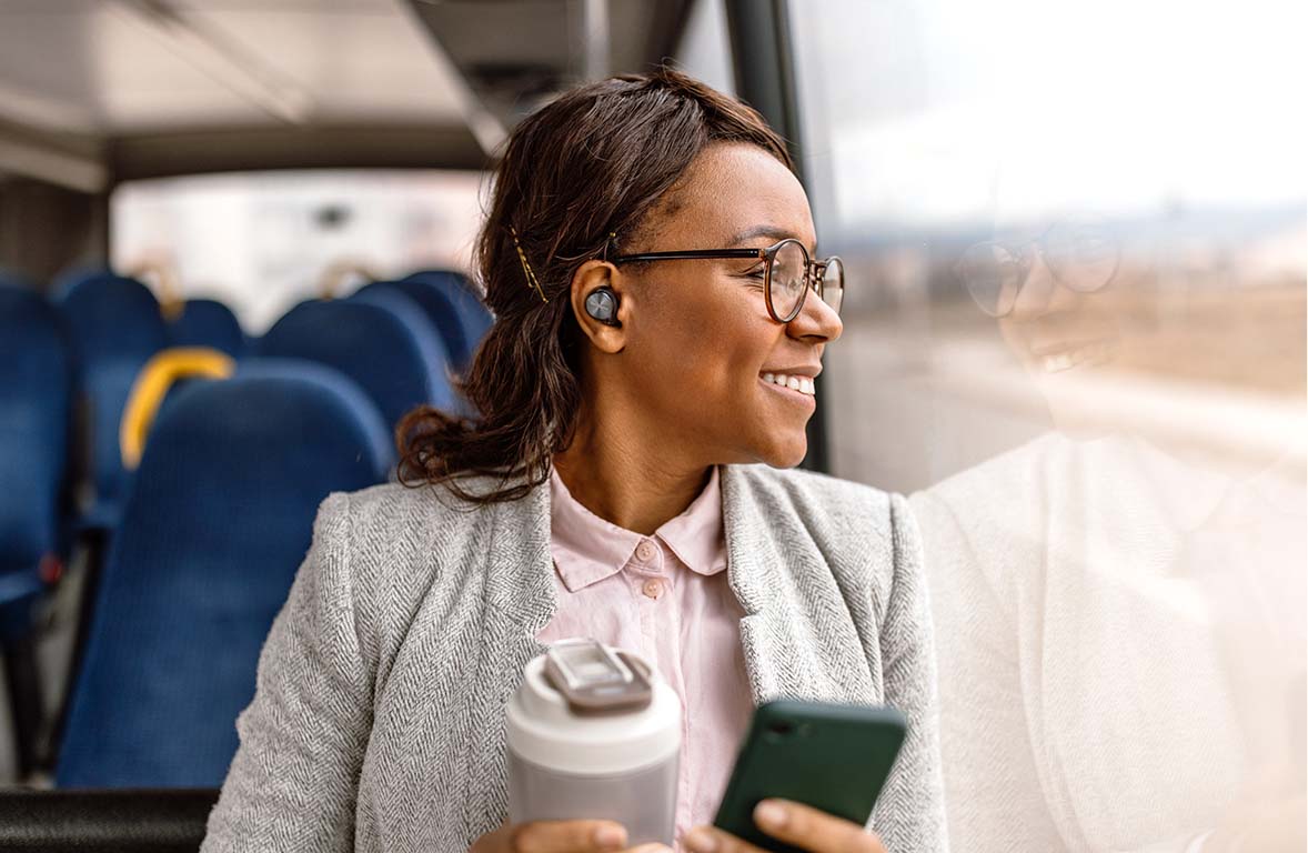 Woman wearing Technics earbuds while on the train