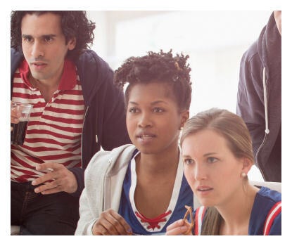 Trois personnes qui regardent attentivement quelque chose dans un cadre décontracté.