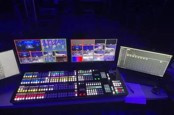 Multicolored broadcast control panel with multiple display screens.