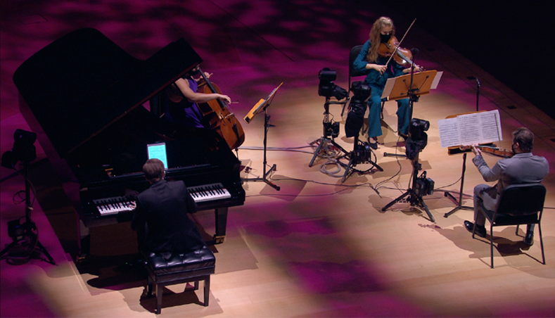 Des musiciens se produisant sur scène avec des équipements de caméra autour d'eux.