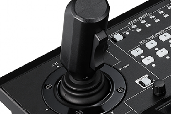 Joystick controller on a panel with multiple buttons and switches.