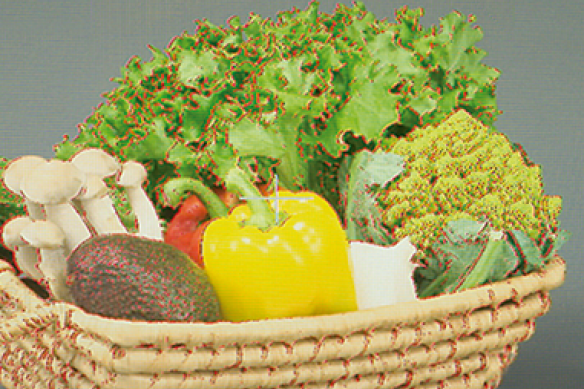 Wicker basket filled with assorted fresh vegetables.