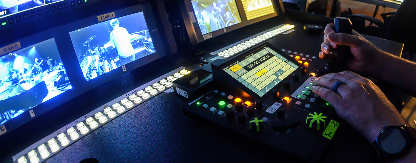 Broadcasting equipment with multiple monitors and control panels.
