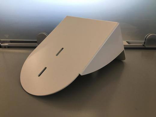 Support de montage mural blanc pour les caméras PTZ sur une surface grise.