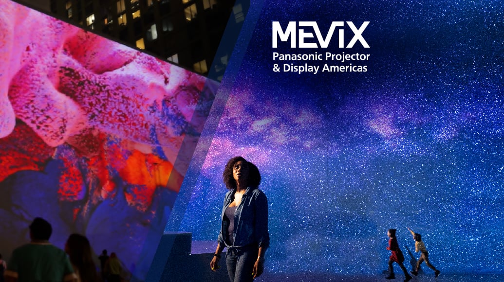 Woman on a stage with images projected on all the walls around her.